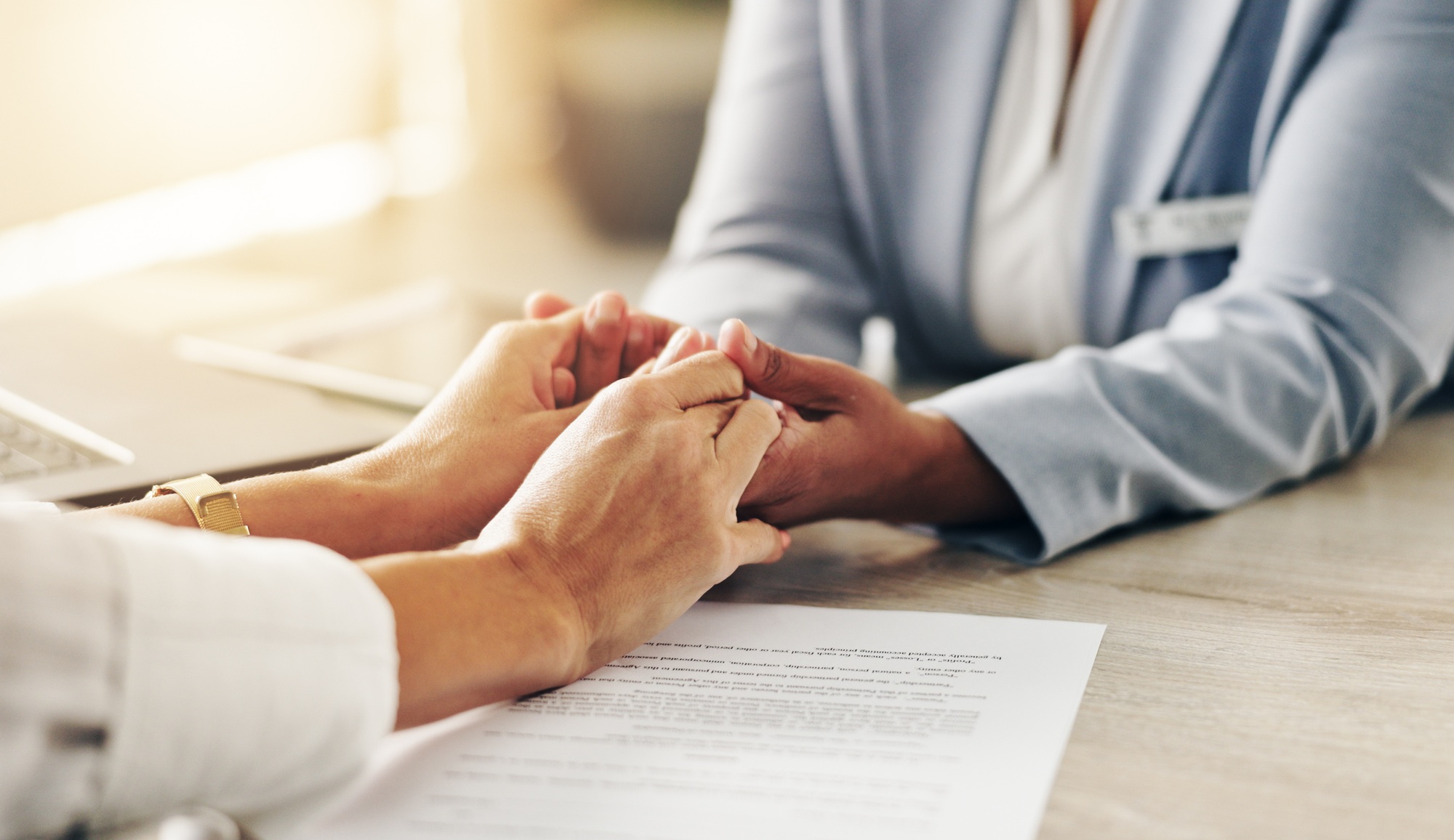 Doctor, patient and holding hands with empathy for consultation, therapy or counseling at clinic. C